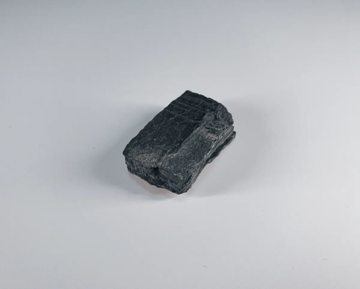 A matte block of coal on a white background