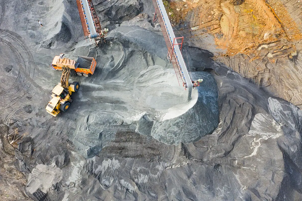 Aerial view of a coal stockpile, conveyors and a loader filling a truck
